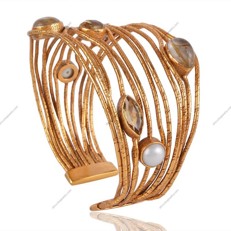 Handcrafted gold-plated cuff bracelet with rutilated quartz and pearl accents, adjustable design.