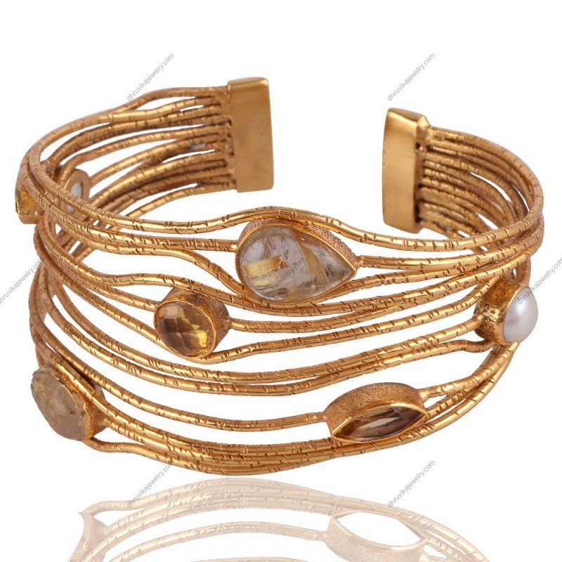 Handcrafted gold-plated cuff bracelet with rutilated quartz and pearl accents, adjustable design.