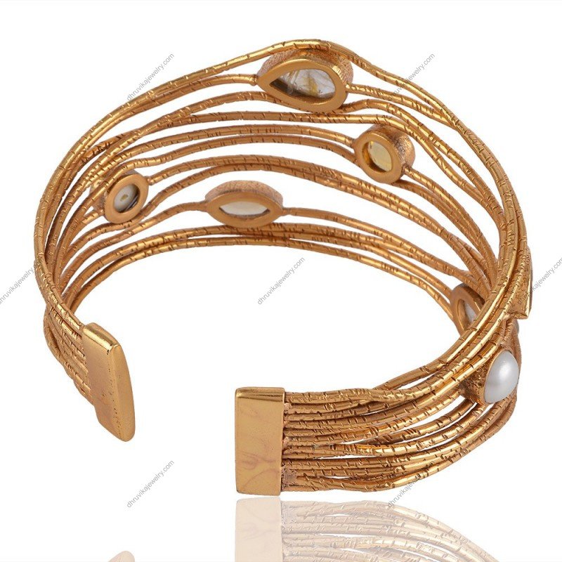 Handcrafted gold-plated cuff bracelet with rutilated quartz and pearl accents, adjustable design.