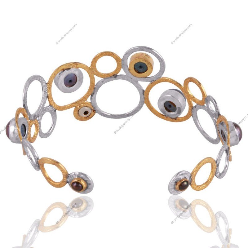 Handmade silver and gold cuff bracelet with black pearls in an openwork design